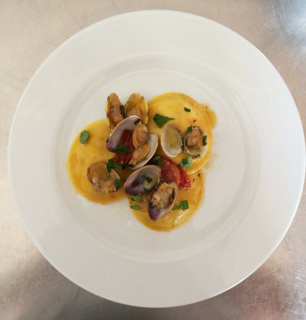 Raviolo ripieno di capesante e gamberetti con vongole e pomodorini confit.